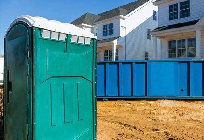 a row of blue and white porta potties on a busy job site